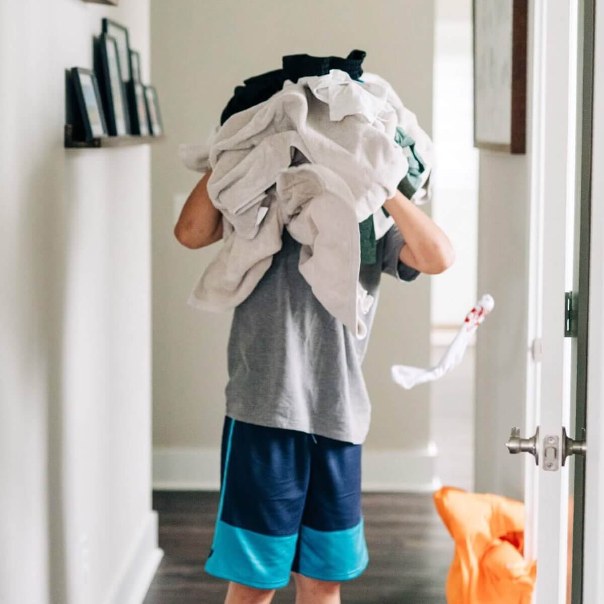 boy covering face with lots of clothes